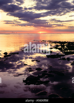 Die untergehende Sonne über Saltburn Strand, Cleveland, UK. Industrial Teesside entnehmen bitte den Abstand auf der linken Seite. Stockfoto