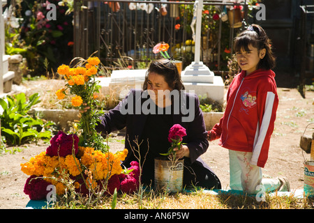 Mexiko Guanajuato Frau und junges Mädchen schmücken Grab mit Ringelblumen und Blumen im Friedhof Tag der toten Feier Stockfoto