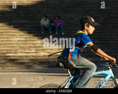 Mexiko Guanajuato Young Boy Reiten Fahrrad im Plaza in der Nähe von Alhondiga paar sitzt auf Schritte im Schatten Stockfoto