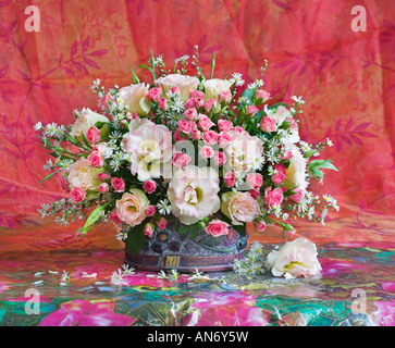 Studio arrangiert Bündel Blumenstrauß aus den weißen Anemonen und rosa Rosen im Korb auf einem Pastell roter Hintergrund Stockfoto