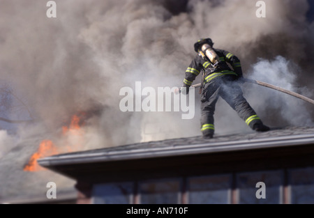 Feuerwehrmann auf dem Dach ein Löschangriff Stockfoto