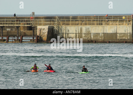 Drei Kanuten paddeln am Eingang zum Hafen von Shoreham und wo fließt der Fluss Adur heraus zum Ärmelkanal. Stockfoto