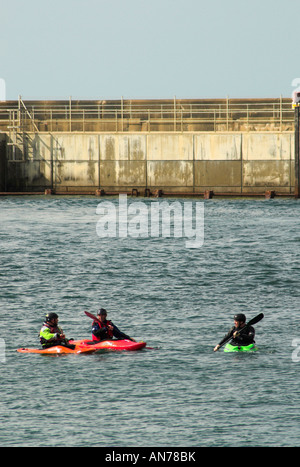 Drei Kanuten paddeln am Eingang zum Hafen von Shoreham und wo fließt der Fluss Adur heraus zum Ärmelkanal. Stockfoto