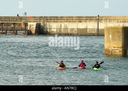 Drei Kanuten paddeln am Eingang zum Hafen von Shoreham und wo fließt der Fluss Adur heraus zum Ärmelkanal. Stockfoto