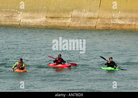 Drei Kanuten paddeln am Eingang zum Hafen von Shoreham und wo fließt der Fluss Adur heraus zum Ärmelkanal. Stockfoto