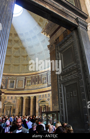 Touristen Gewimmel der hohe Eingang zu den Pantheon Massive Messing-Türen öffnen, die geschwungene Kuppel einen Strahl der Sonne durchschneidet Stockfoto