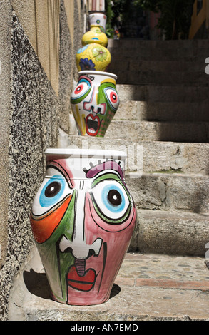 Eine Reihe von wunderlich und leuchtend bunt bemalte Keramik Keramik Urnen angeordnet in der Sonne eine Reihe von alten Schritte Stockfoto