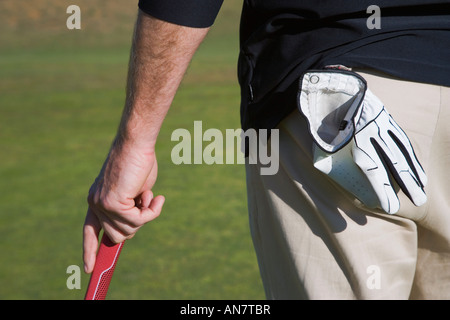 Nahaufnahme der Golfer mit Handschuh in Gesäßtasche stützte sich auf Golf-stick Stockfoto