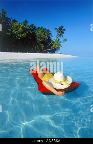 Frau auf Luftmatratze im tropischen Paradies Stockfoto