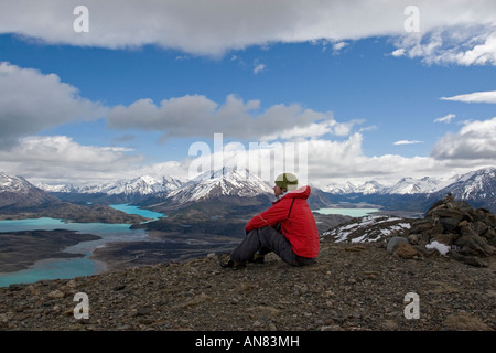 Mann in rote Jacke saß auf Hügel Landschaft zu bewundern Stockfoto