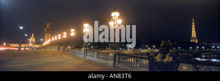 Pont Alexandre III mit Eiffelturm, Lampe leuchtet und Hotel des Invalides in Paris nachts Stockfoto