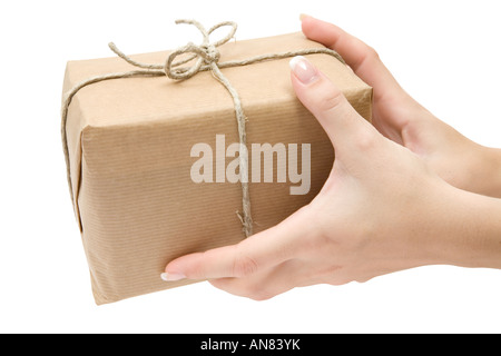 Weibliche Hände halten eine braune Paket. Isoliert auf weißem Hintergrund. Stockfoto