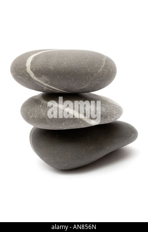 Drei grauen Steinen auf einander gestapelt. Isoliert auf weißem Hintergrund. Stockfoto