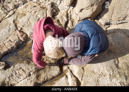 Ein Farbbild Landschaft zwei junge Brüder spielen unter den Felsenpools während des Urlaubs entlang der Küste von Dorset. Stockfoto