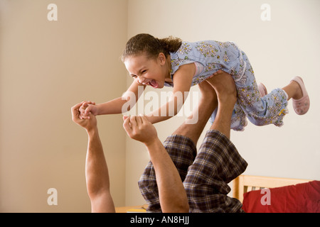 Afrikanische Mädchen balancieren auf Vaters Füße Stockfoto