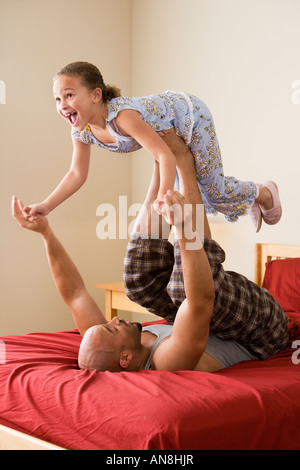 Afrikanische Mädchen balancieren auf Vaters Füße Stockfoto