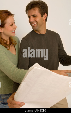 Porträt von ein attraktives Paar mit Blick auf Haus Pläne Stockfoto