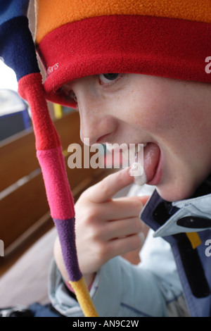 Finger leckt gutes Getränk vor einem Bergrestaurant in Saalbach-Hinterglemm, Österreich Stockfoto