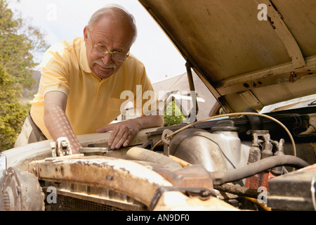 Senior woman Blick auf Auto-Motor Stockfoto