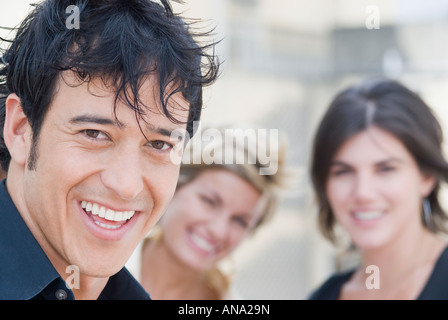 Hispanic Mann lächelnd mit Freunden im Hintergrund Stockfoto