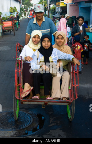 Drei muslimische Mädchen reiten in einem Becak-Rikscha Yogyakarta Java Indonesien Stockfoto