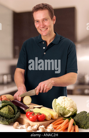 MANN IN DER KÜCHE VORBEREITEN GEMÜSE Stockfoto