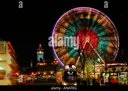 Princes Street, Edinburgh, Schottland während Weihnachten Winter feiern Riesenrad auf den richtigen Bussen reisen entlang der Straße Stockfoto