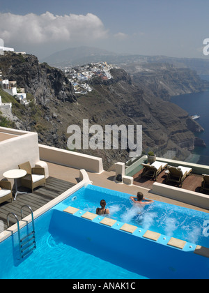 Swimmingpool des Hotels auf der Klippe mit der Stadt Thira in der Ferne auf der griechischen Insel Santorini Stockfoto