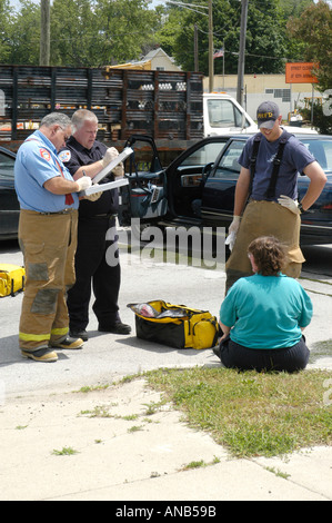Notfall Arbeiter helfen weibliche Opfer im Auto Auto Auto Unfall Stockfoto