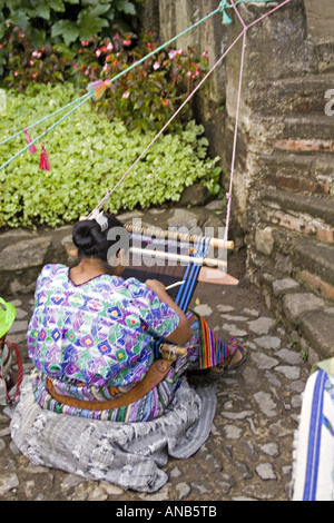 GUATEMALA ANTIGUA Cakchiquel Maya-Frau trägt traditionelle Huipil und Corte mit einem Backstrap Loom um zu weben von Textilien Stockfoto