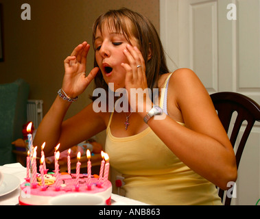 Junges Mädchen bläst Kerzen auf Geburtstagskuchen Stockfoto