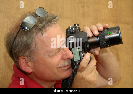 Ein professioneller Fotograf testet eine neue digitale SLR-Kamera mit einem Makro-Objektiv montiert. Stockfoto