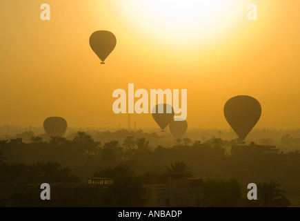 Heißluftballons in goldenen Sonnenaufgang Schein über den Nil und Ägypten Luxor Landschaft Stockfoto