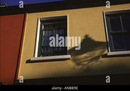 Eine Straße Lampe Schatten fällt auf in der Regel hell lackiert Gebäude Westport irischen Westküste Stockfoto