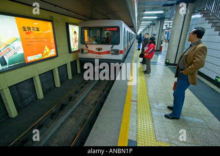 Chinesische Leute warten, wie Zug in der Station Plattform Peking China zieht Stockfoto