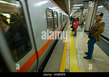 Chinesische Leute warten, wie Zug in der Station Plattform Peking China zieht Stockfoto