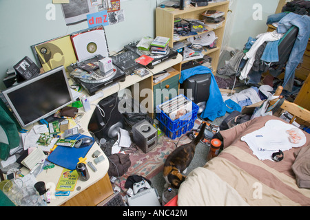 EINE MÄNNLICHE TEENAGER-SCHLAFZIMMER IN EIN DURCHEINANDER MIT KLEIDUNG UND MÜLL ÜBERALL LIEGEN Stockfoto