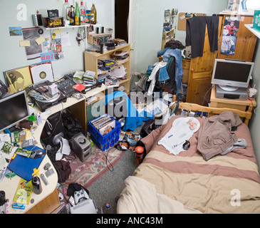 EINE MÄNNLICHE TEENAGER-SCHLAFZIMMER IN EIN DURCHEINANDER MIT KLEIDUNG UND MÜLL ÜBERALL LIEGEN Stockfoto