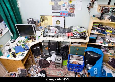 EINE MÄNNLICHE TEENAGER-SCHLAFZIMMER IN EIN DURCHEINANDER MIT KLEIDUNG UND MÜLL ÜBERALL LIEGEN Stockfoto