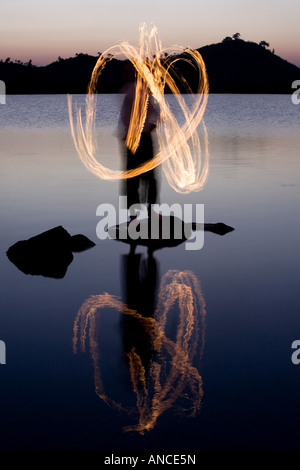 Menschen das Feuer tanzen auf einem Felsen in einem See in Indien Stockfoto