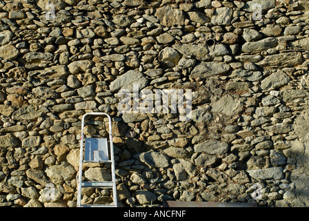 Eine steinerne Wand gelehnt Metallleiter Stockfoto