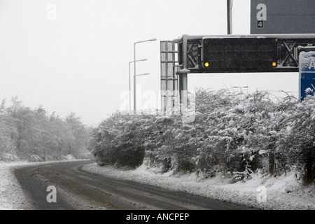 leere Schneematsch bedeckt Straße neben Autobahn Warnschild Stockfoto