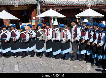 Naxi Frauen in traditioneller Tracht und ein Mann führen ihre täglichen Tanz und Routine Sifang Square Lijiang Yunnan China-Übung Stockfoto