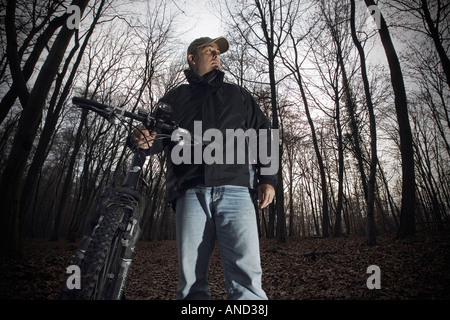 Mittleren Alter Mann mit einem Fahrrad in einem Wald Dezember 2007 Stockfoto