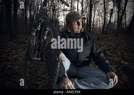 Mittleren Alter Mann mit einem Fahrrad sitzen in einem Wald Dezember 2007 Stockfoto