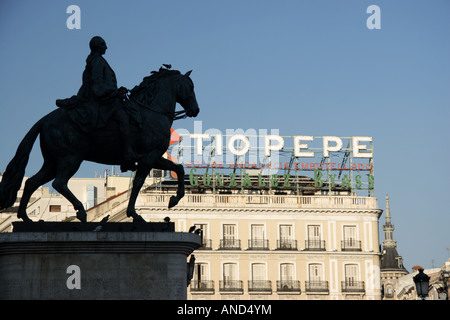 Am berühmten Tio Pepe Schild am Puerta del Sol und Reiterstatue von Carlos III, Madrid, Spanien. Stockfoto