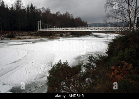 Der Fluss Dee zugefroren unterhalb der Cambus O kann Hängebrücke bei Ballater im Royal Deeside, Schottland, UK Stockfoto