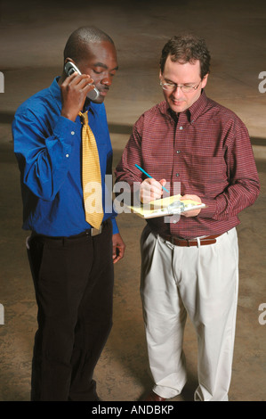 Zwei Unternehmer treffen und planen ein neues Geschäft in einer unvollendeten Werk oder Lager Stockfoto
