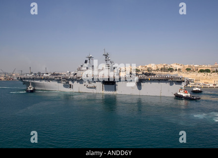 Die Amphibious Assault ship USS Kearsarge ist durch Schleppboote unterstützt, wie sie in Maltas Grand Harbour Schlafplätze Stockfoto