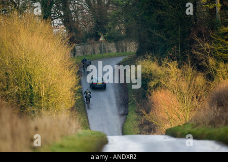 Auto überholt Radfahrer auf der Landstraße in der Nähe von Burford Vereinigtes Königreich Stockfoto